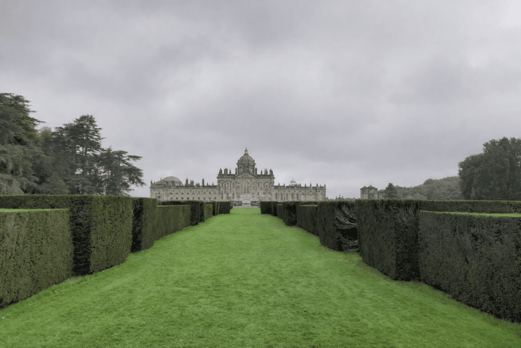 manicured lawns and hedges leading up to Castle Howard in the middle distance